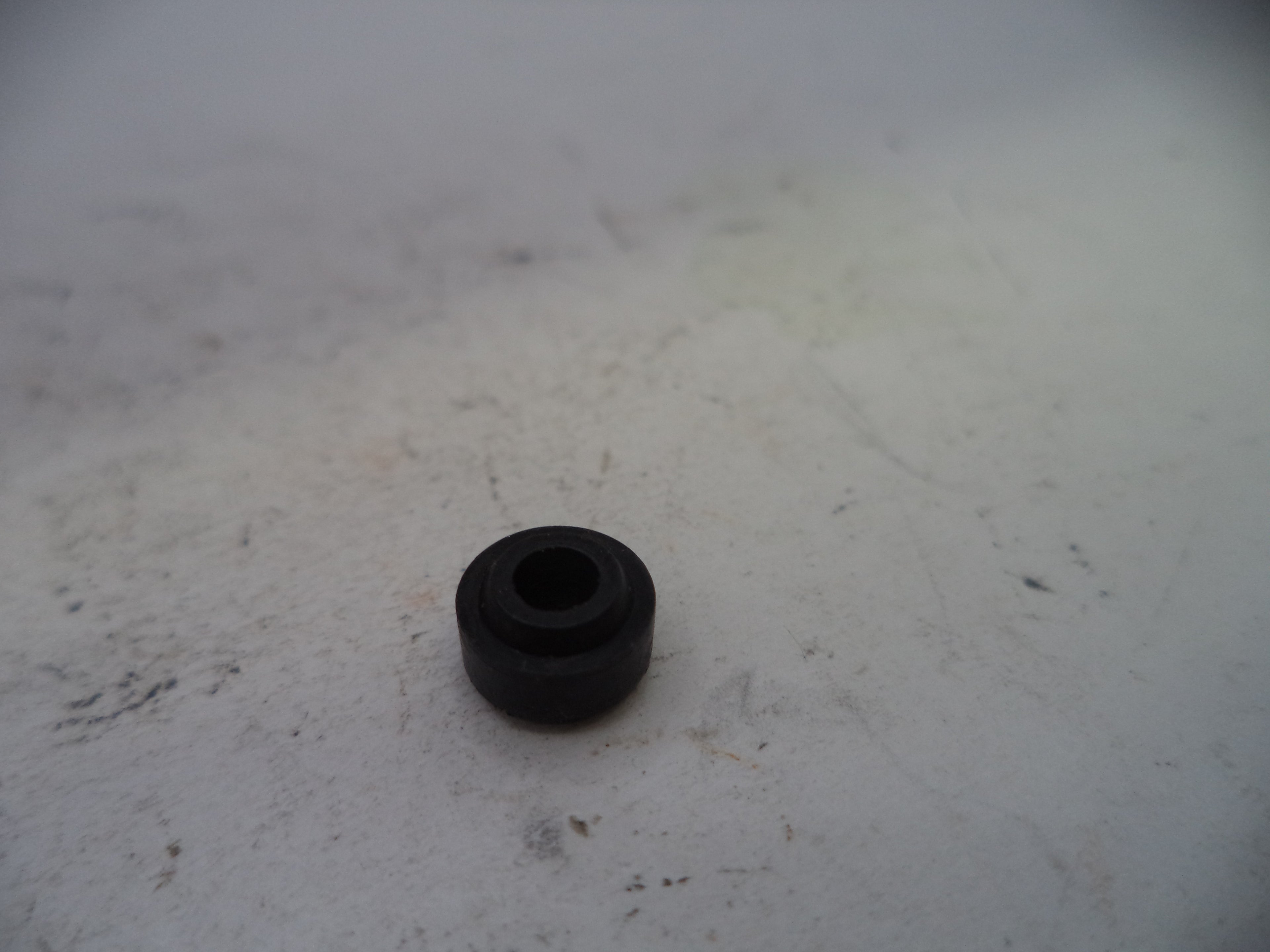 Black rubber bushing on a white surface