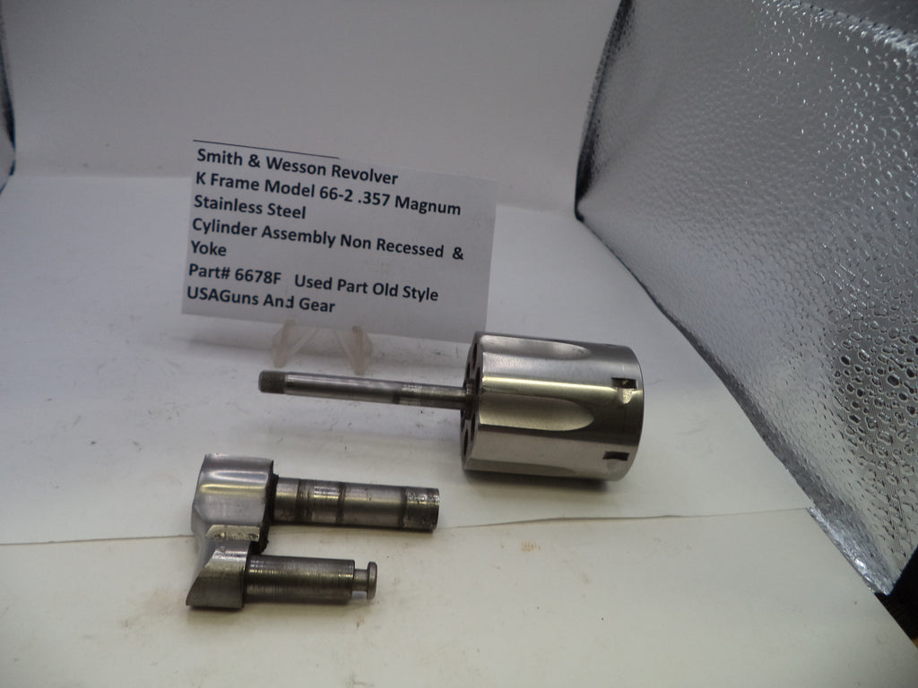Smith & Wesson revolver cylinder assembly on a white surface with a label.