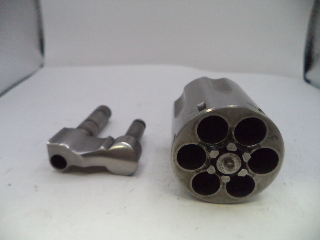 Metallic revolver barrel and cylinder on a white surface