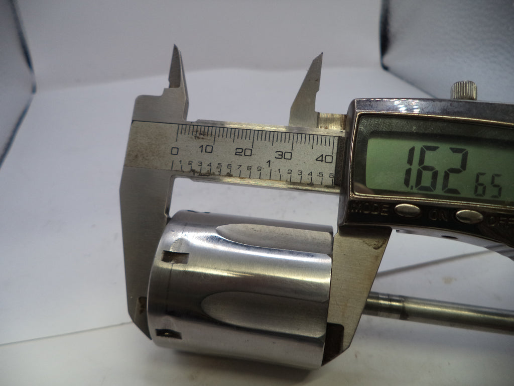 Digital caliper measuring a cylindrical metal object with a white background