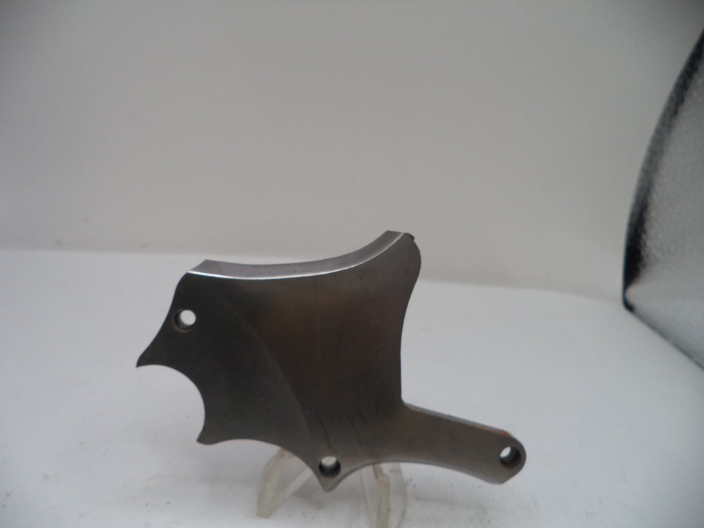 Metallic object on a white surface with a neutral background