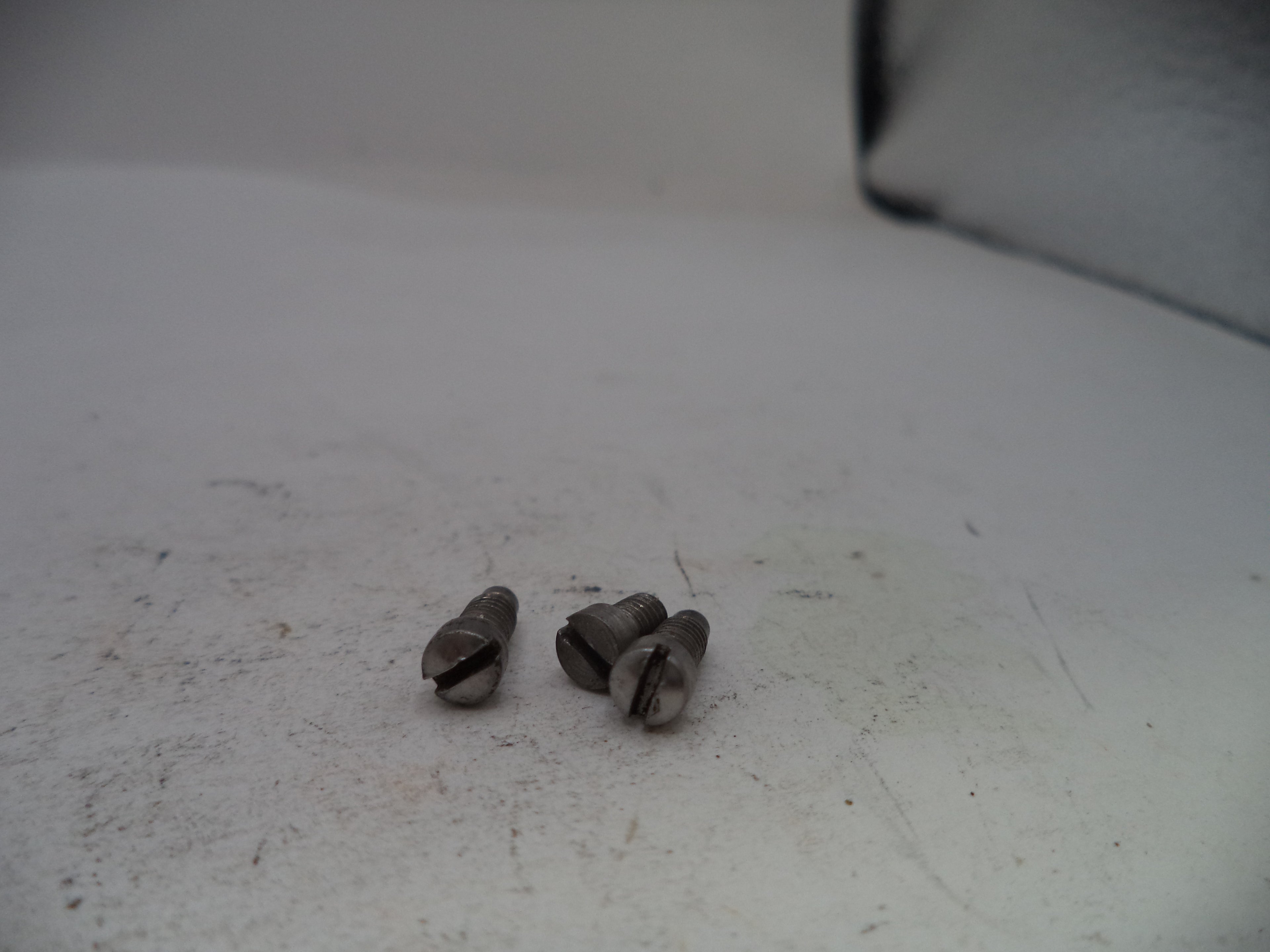 Two small metallic objects on a textured white surface