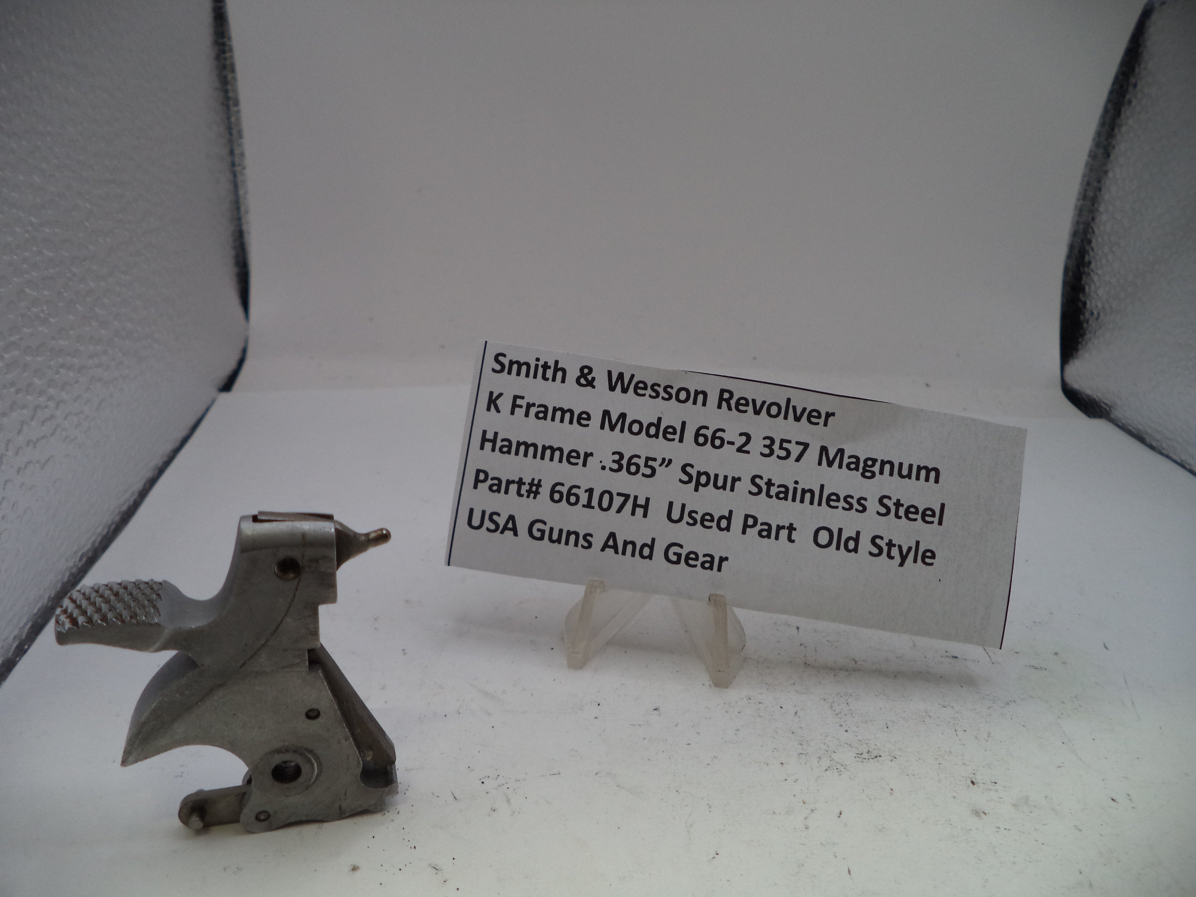 Metal gun part with a label on a white background