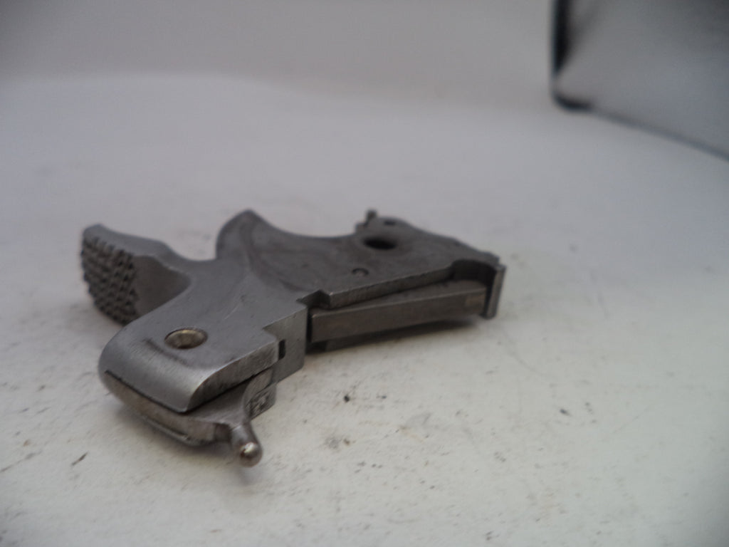 Metallic firearm component on a white surface