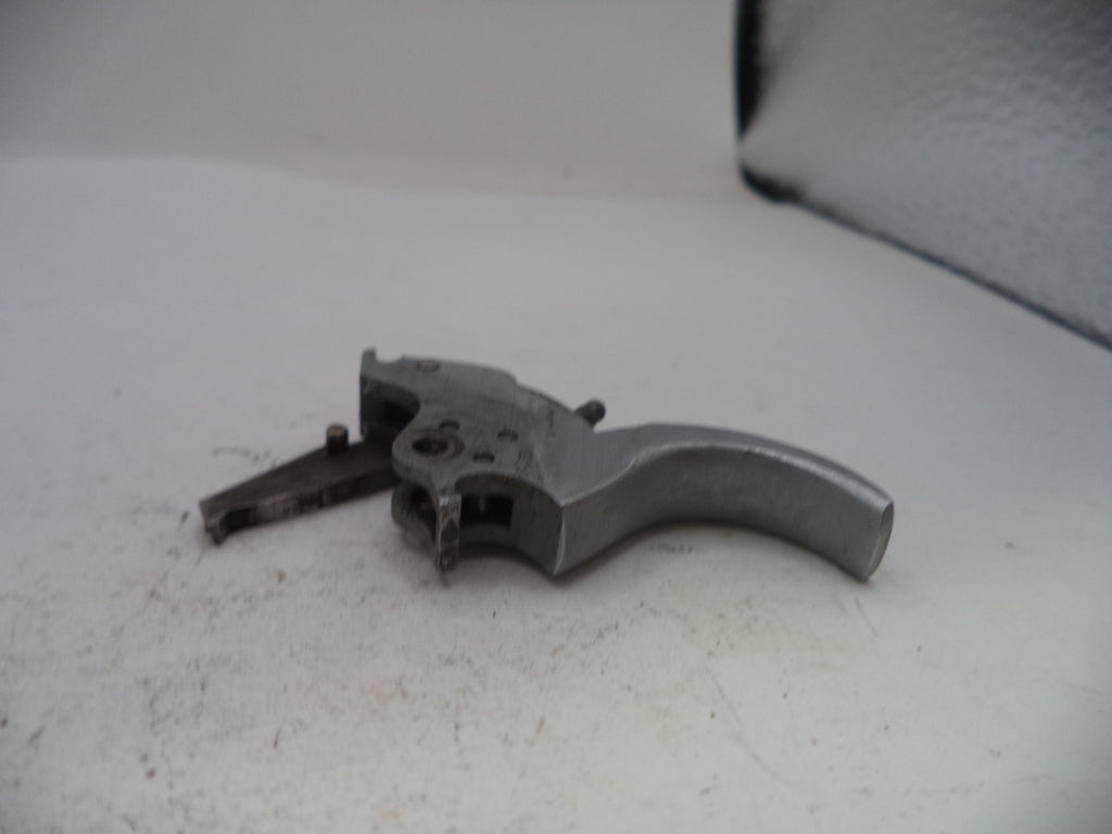 Metal gun trigger on a white surface