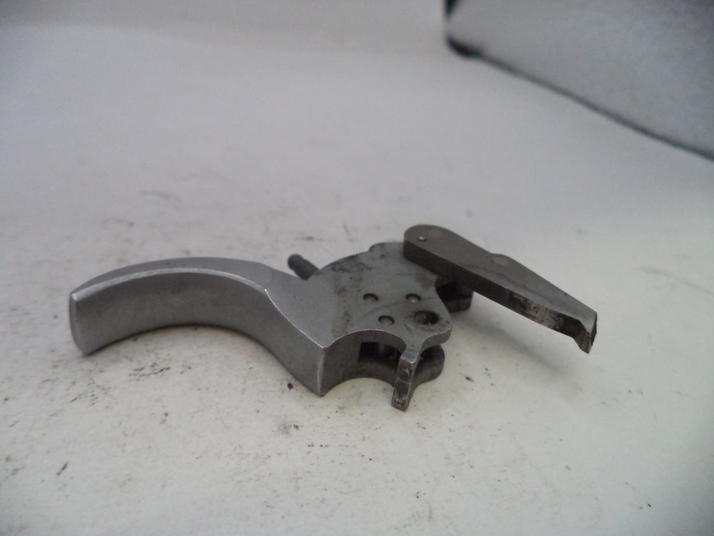 Metallic firearm trigger mechanism on a light gray surface