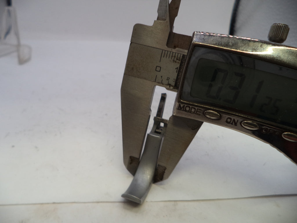 Metallic object being measured with a digital caliper on a white background