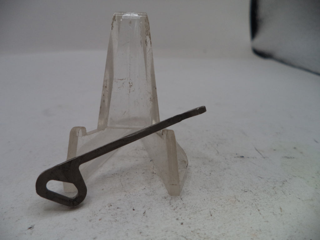 Metal key on a clear plastic stand against a plain background