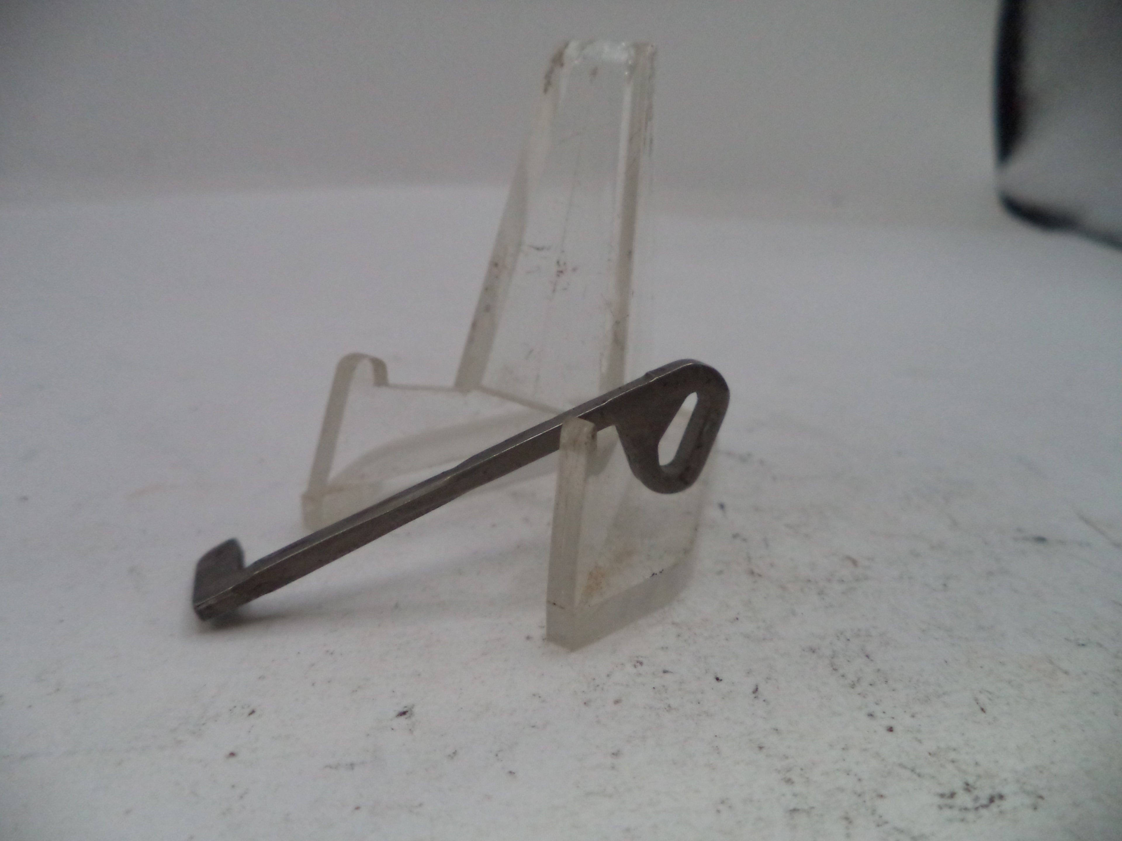 Metal key on a stand against a white background