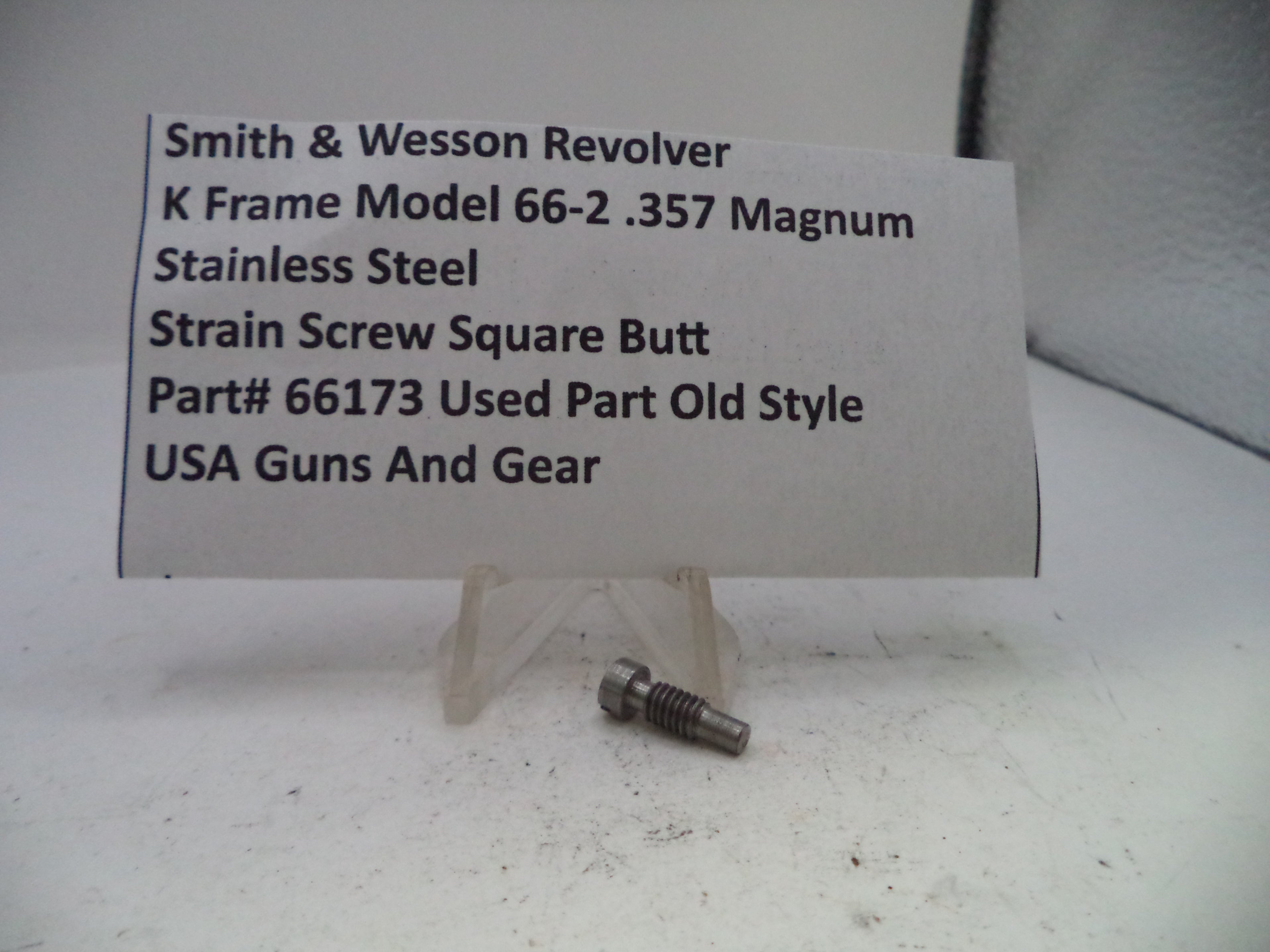 Small metal screw with descriptive label on a white background