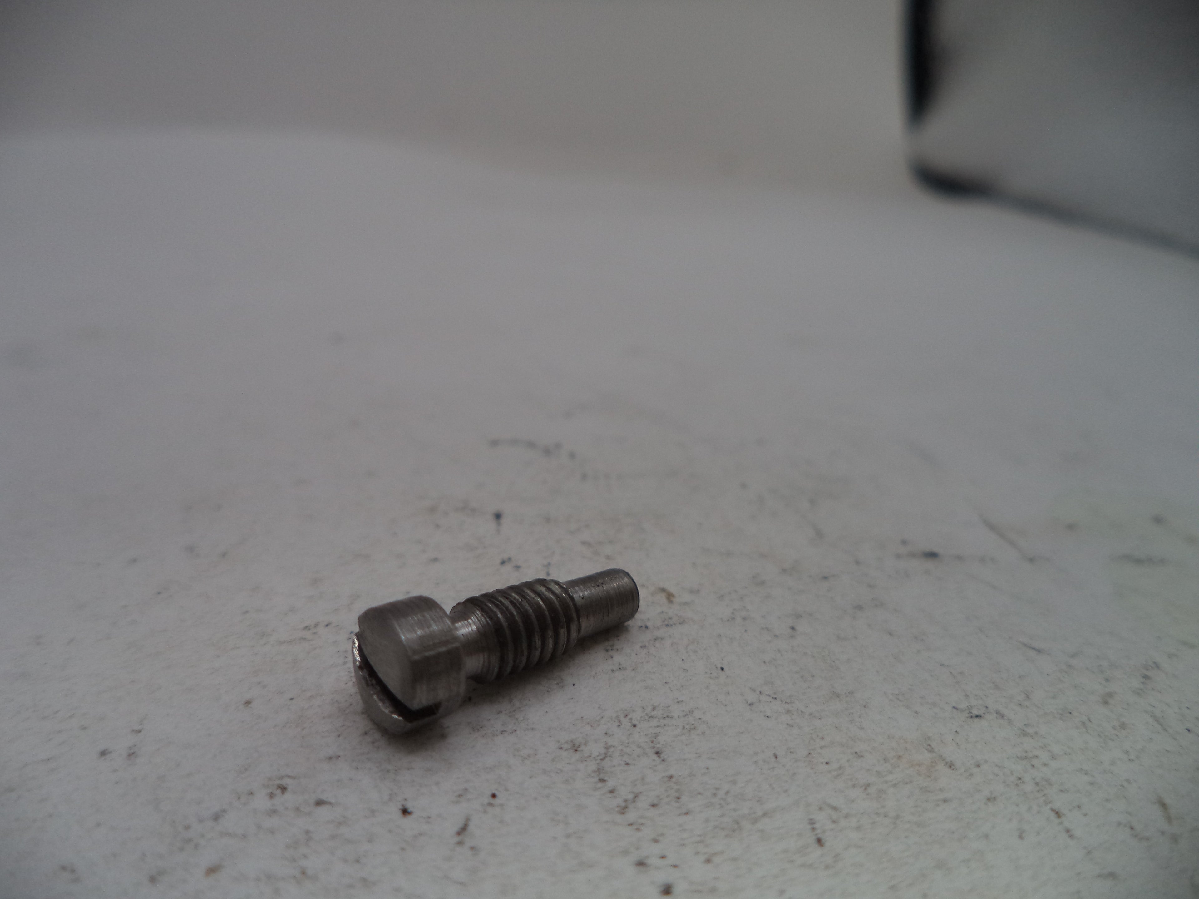 Metal screw on a textured white surface