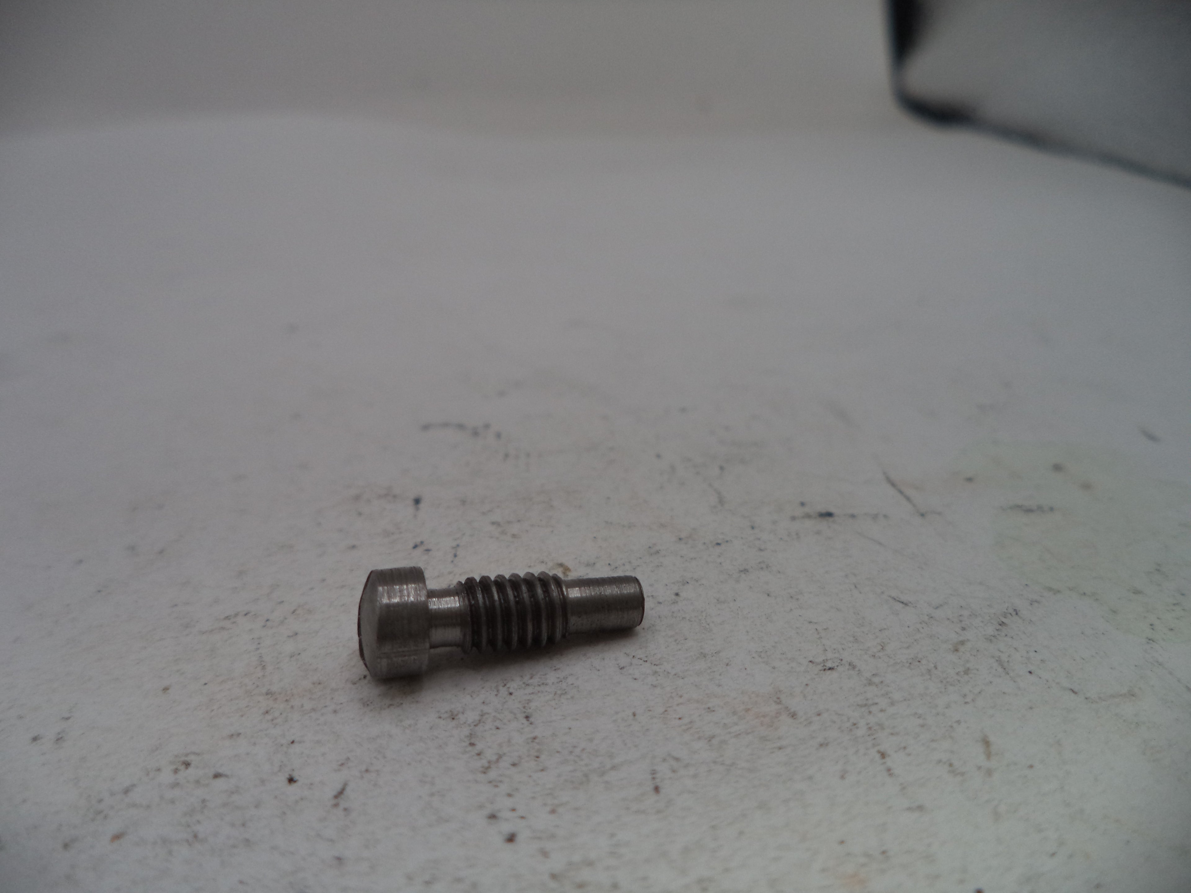 Metal bolt on a textured white surface
