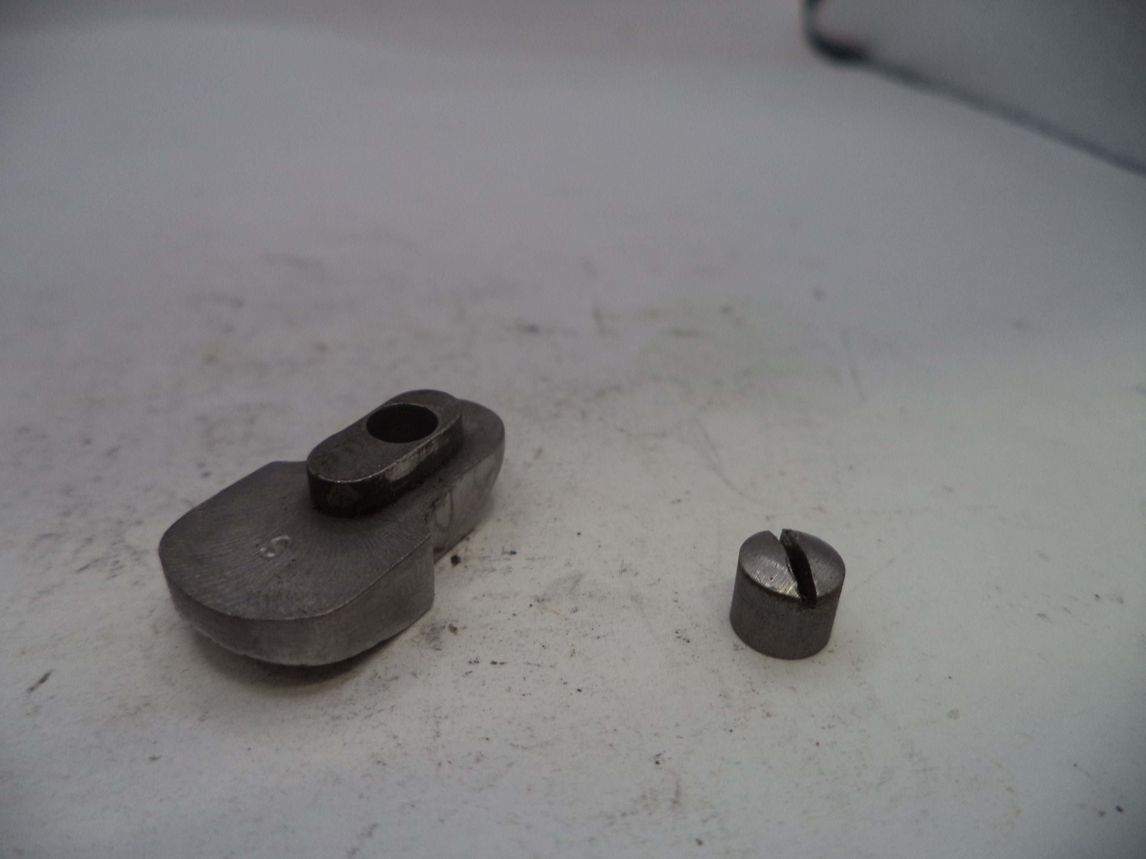 Two metal components on a white surface