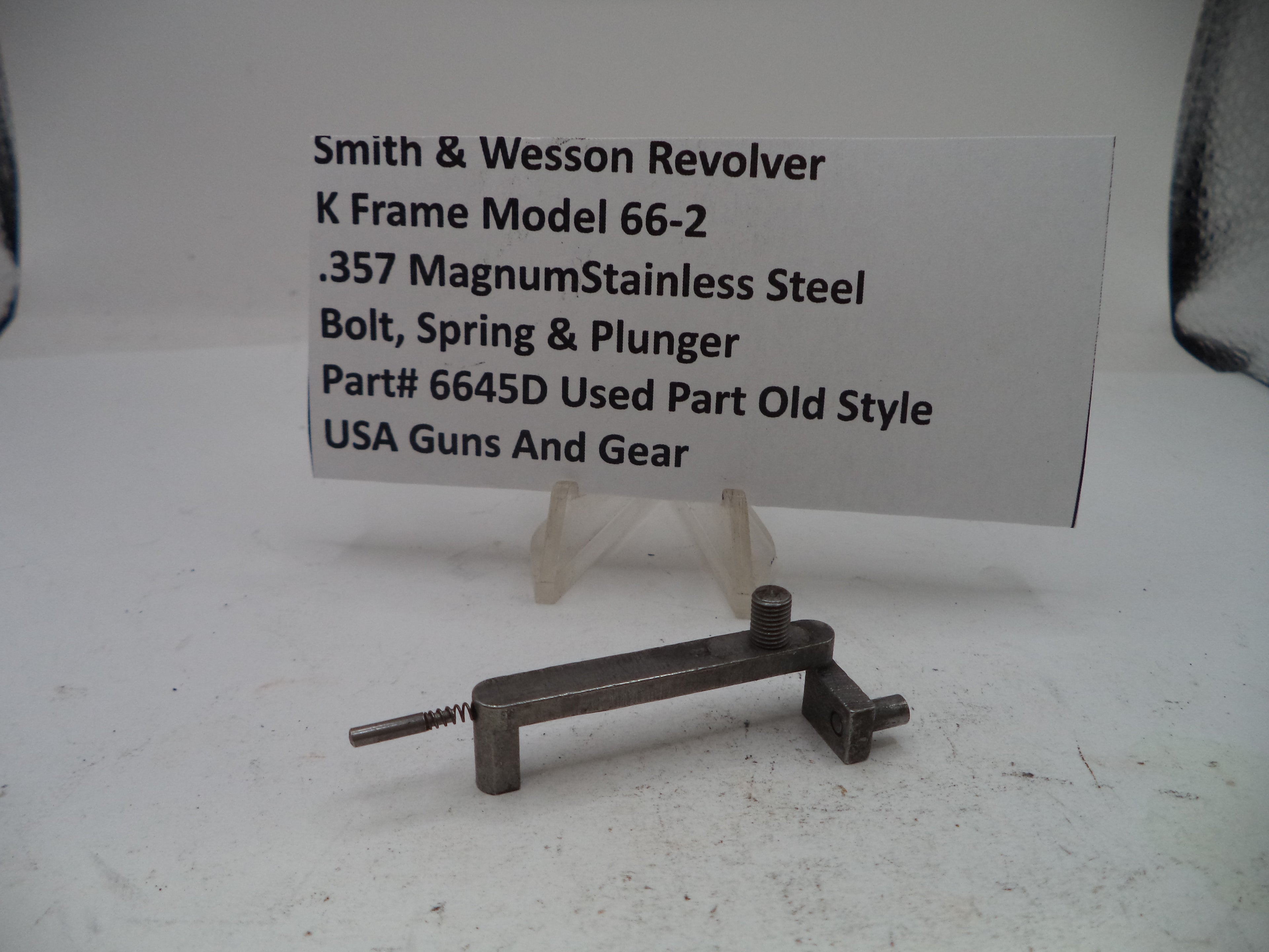 Small metal tool with descriptive text card on a white background