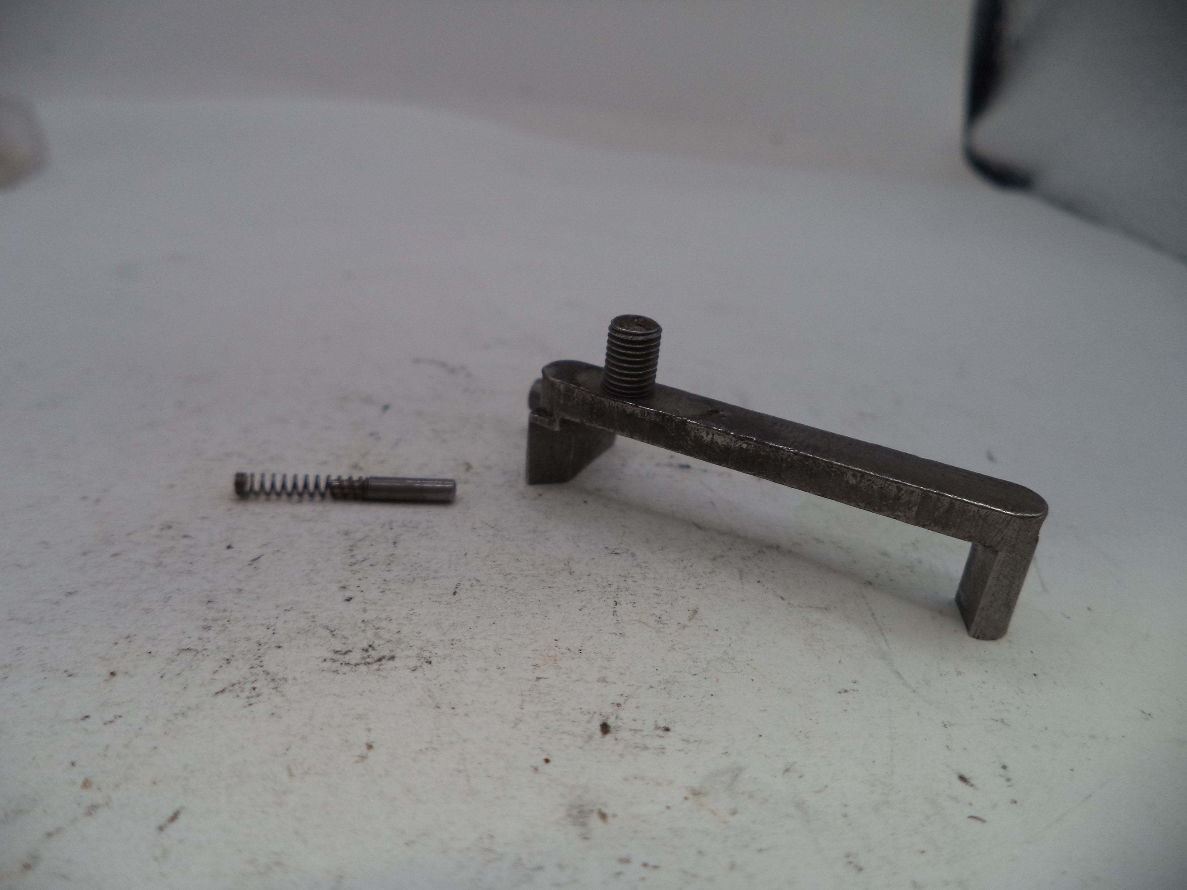 Metal lever and spring on a white surface