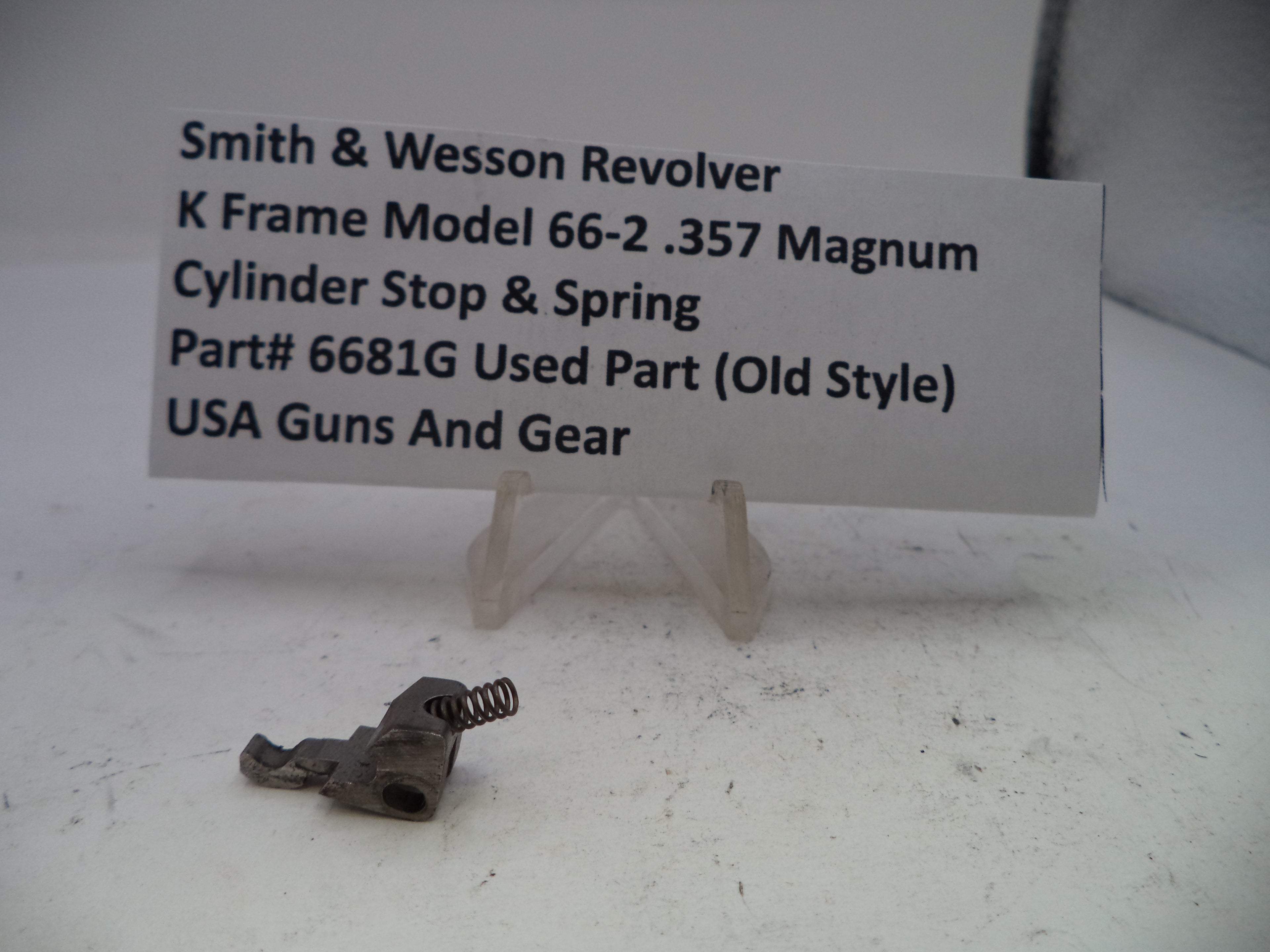 Smith & Wesson revolver cylinder stop and spring with a label on a white surface