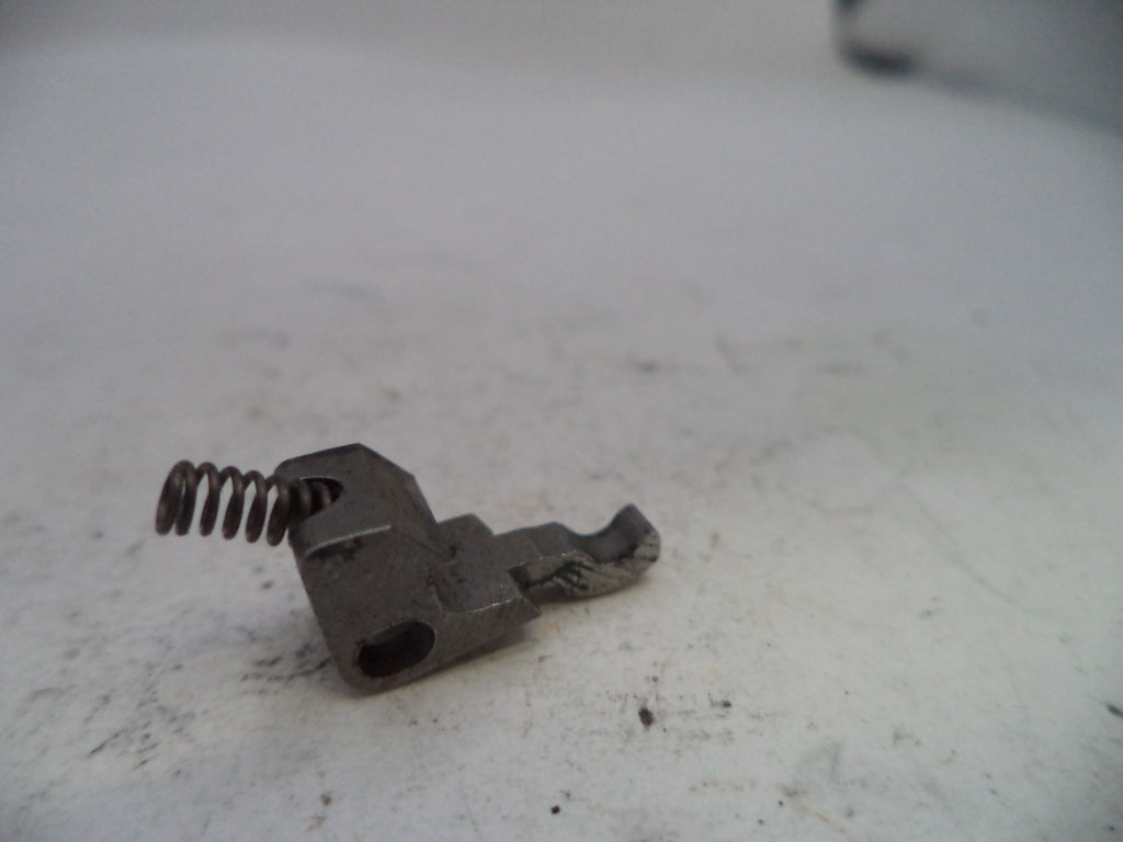 Metal component with a spring on a white surface