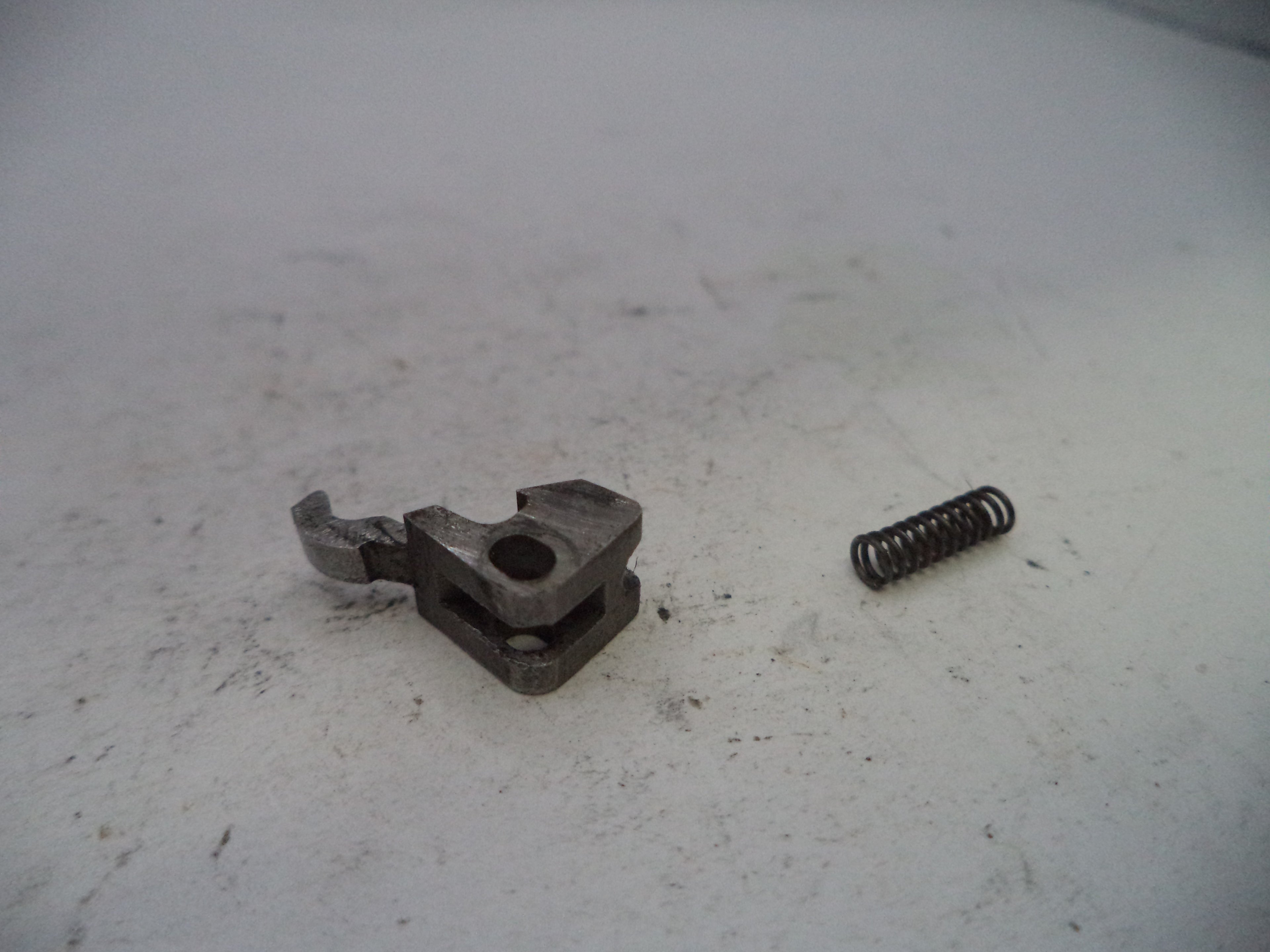 Mechanical component and spring on a white surface