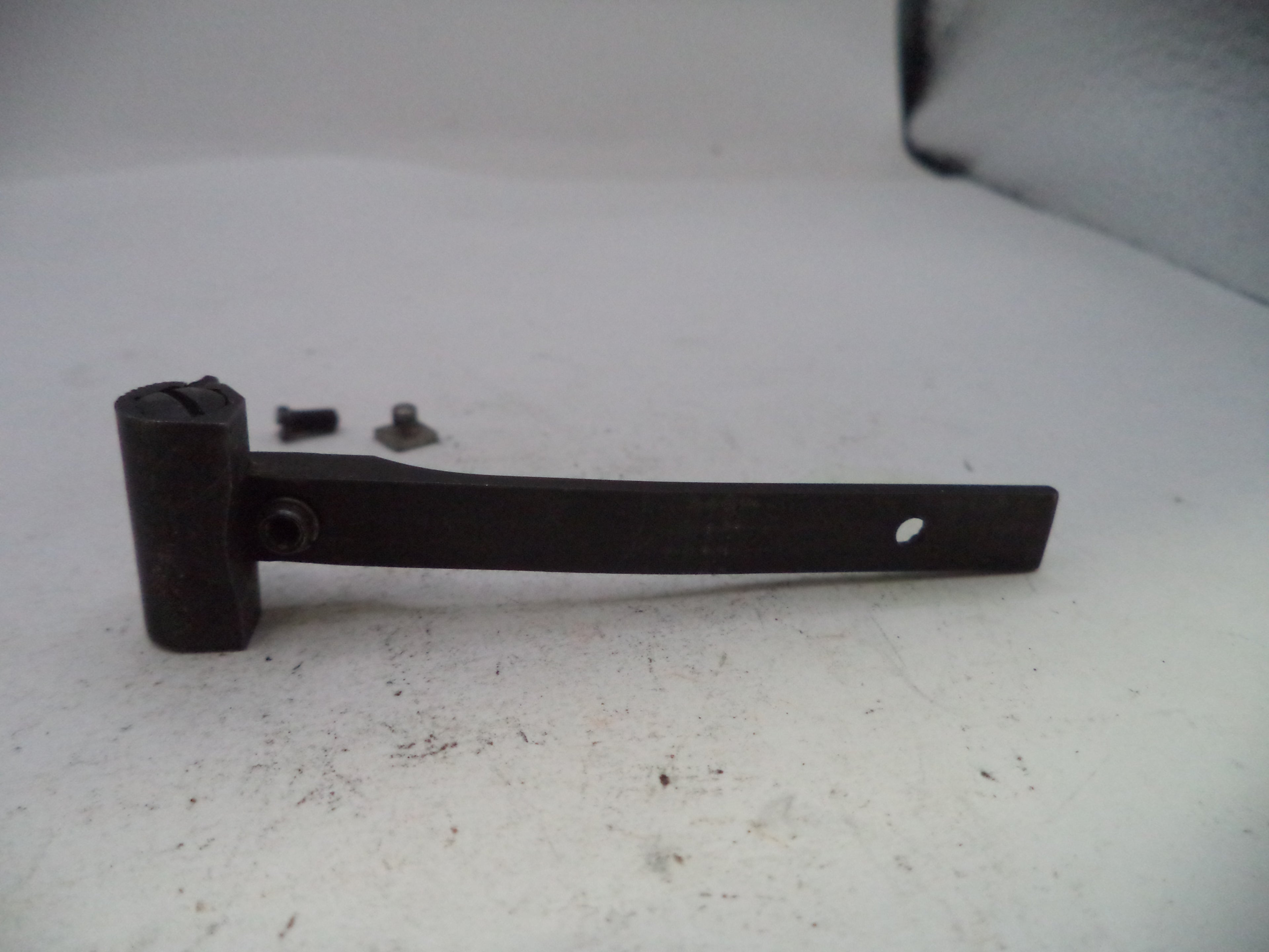 Black metal bracket with screws on a white surface