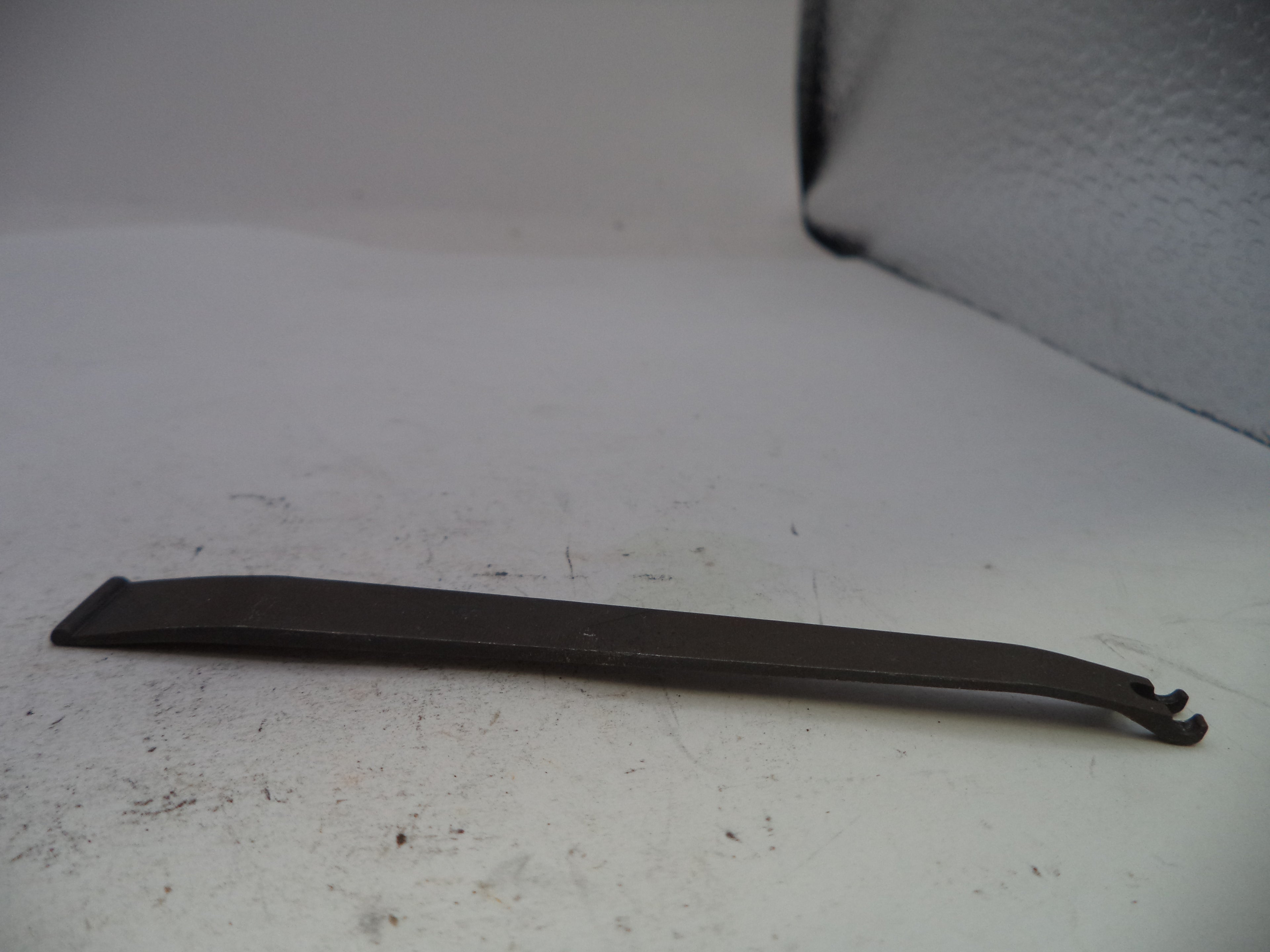 Metal tool on a white surface with a textured background