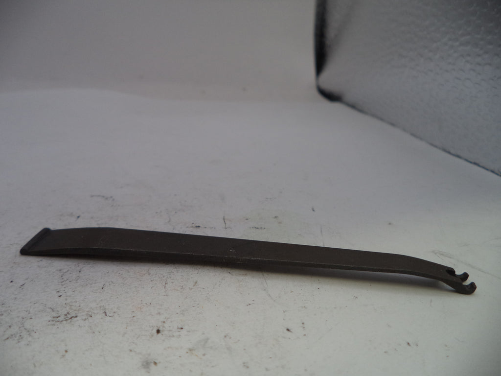 Metal tool on a white surface with a textured background