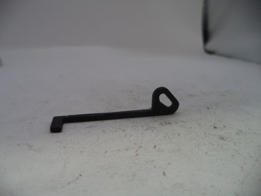 A small black metal key-shaped tool with a loop at one end, photographed on a light gray surface.