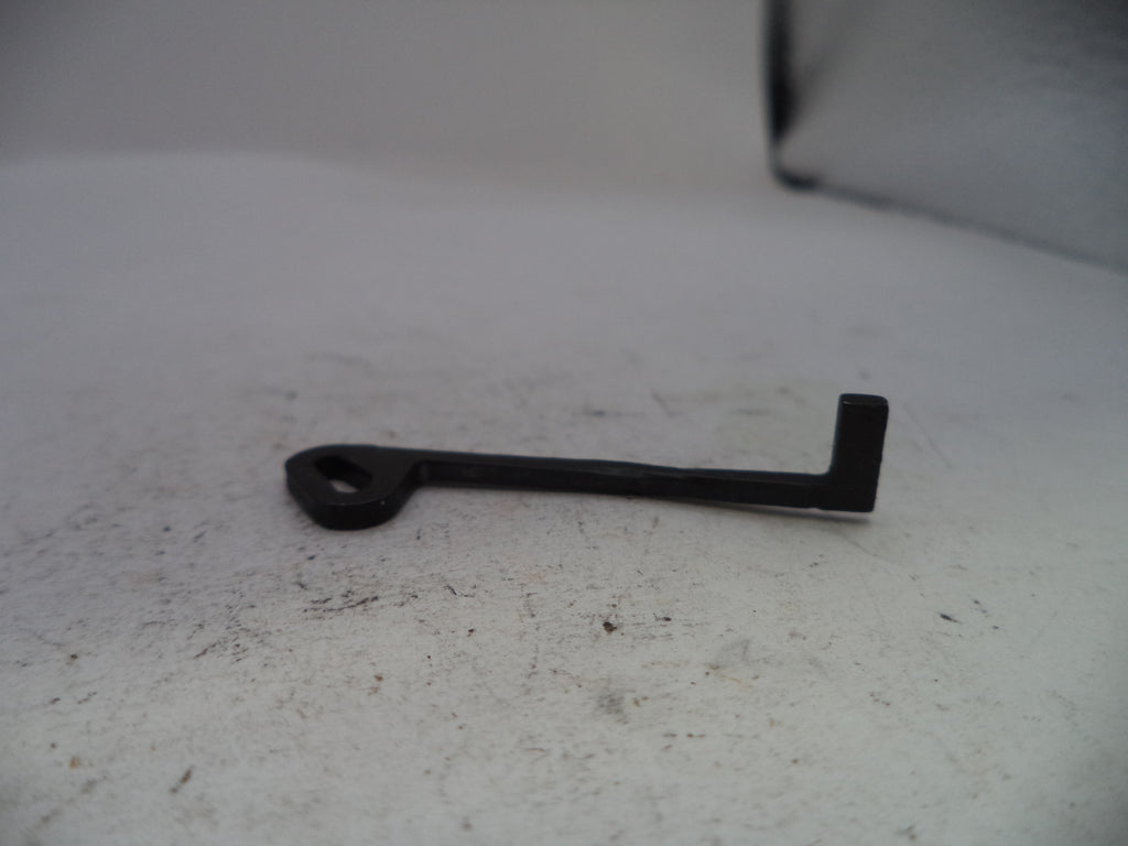 A small black metal key-shaped tool with a looped end, resting on a light gray textured surface.
