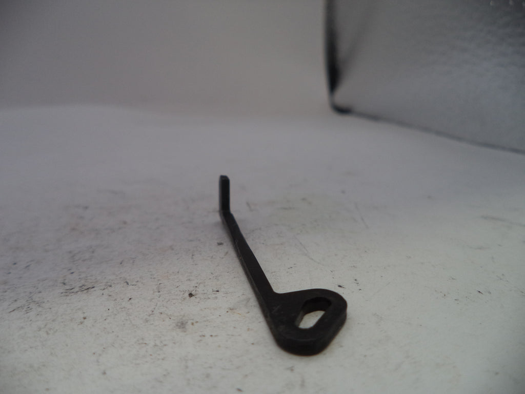 A small black metal mechanical part with a looped end, photographed on a light gray surface.