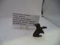 A small dark metal hammer assembly part displayed on a clear stand next to a printed label card for a Smith & Wesson Revolver hammer assembly, photographed against a plain light background.