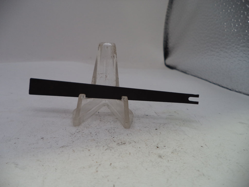 A black metal flat tool with a single prong on one end, displayed on a clear plastic stand against a light gray background.