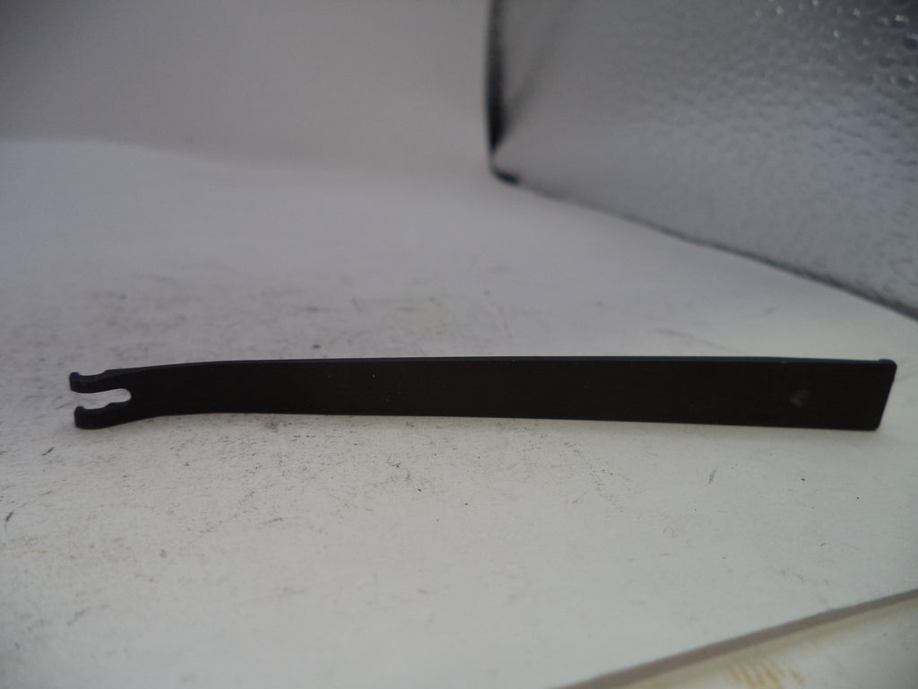 A black metal flathead screwdriver or pry tool with a forked tip, resting on a white surface.