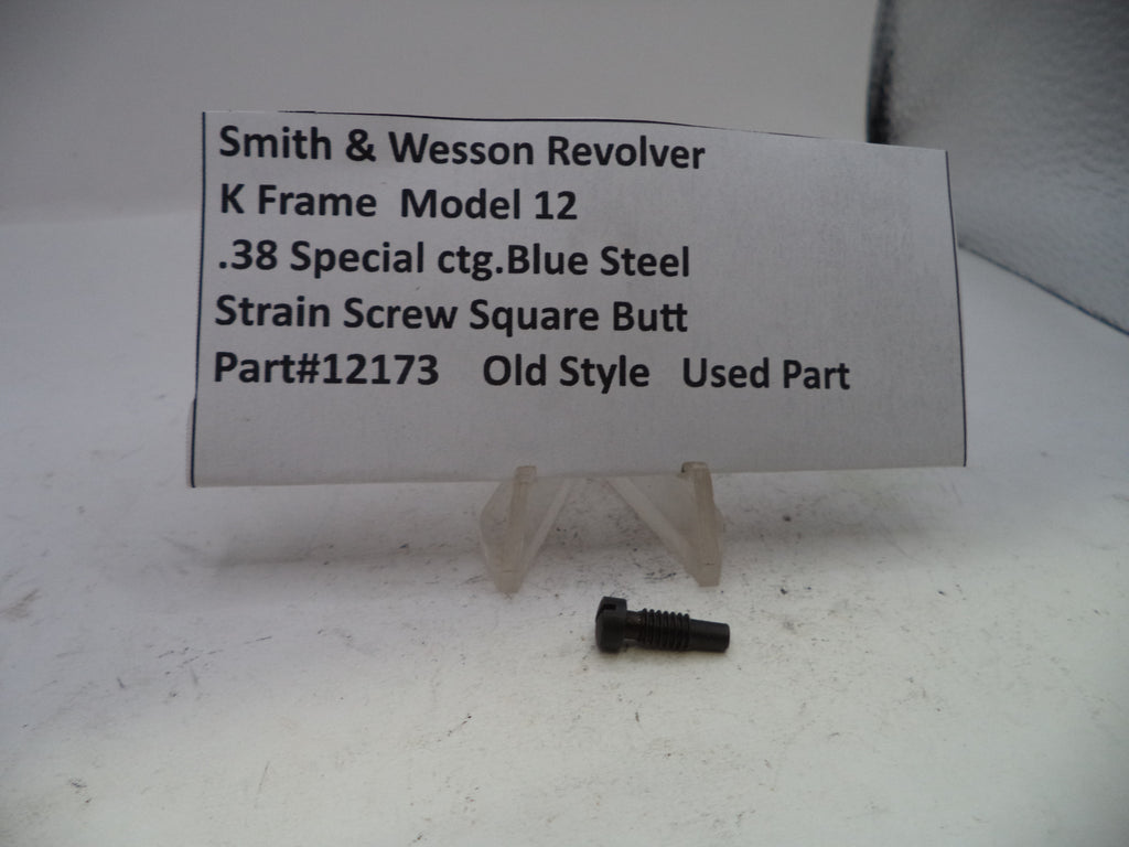 A small used blue steel screw for a Smith & Wesson revolver K frame, displayed on a clear plastic stand next to a white paper label with product details.
