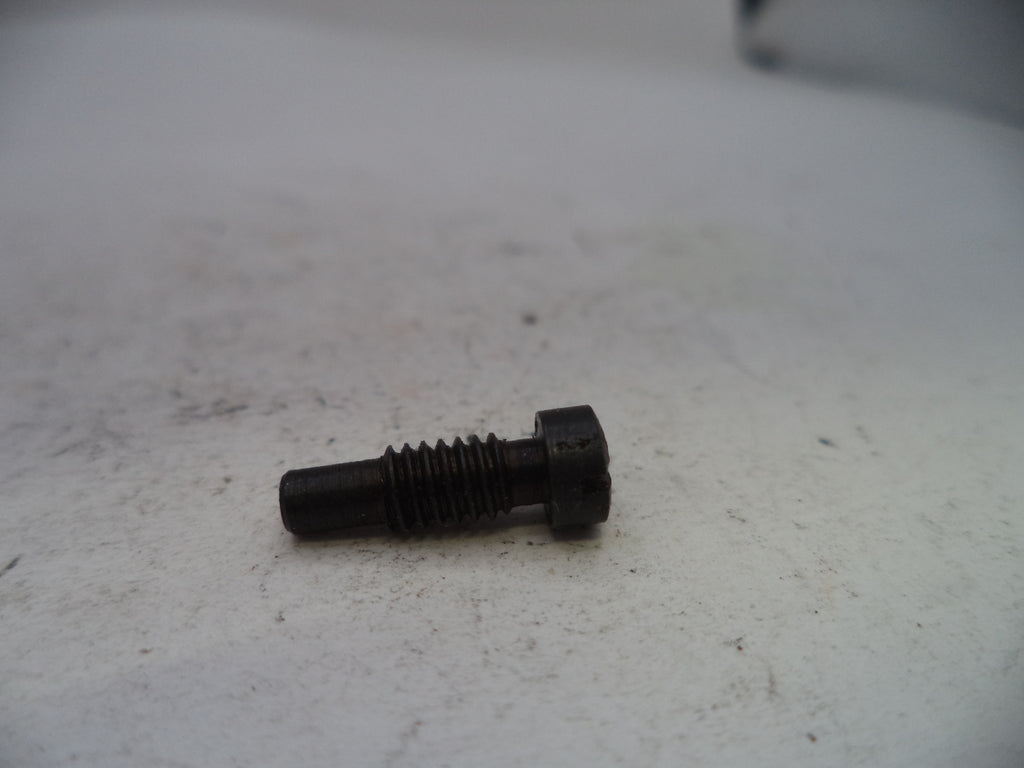 A small black metal threaded bolt or pin with a hex head, resting on a light gray textured surface.