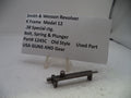 A used metal part for a Smith & Wesson Revolver K Frame Model 12, shown on a clear stand with an informational paper label.