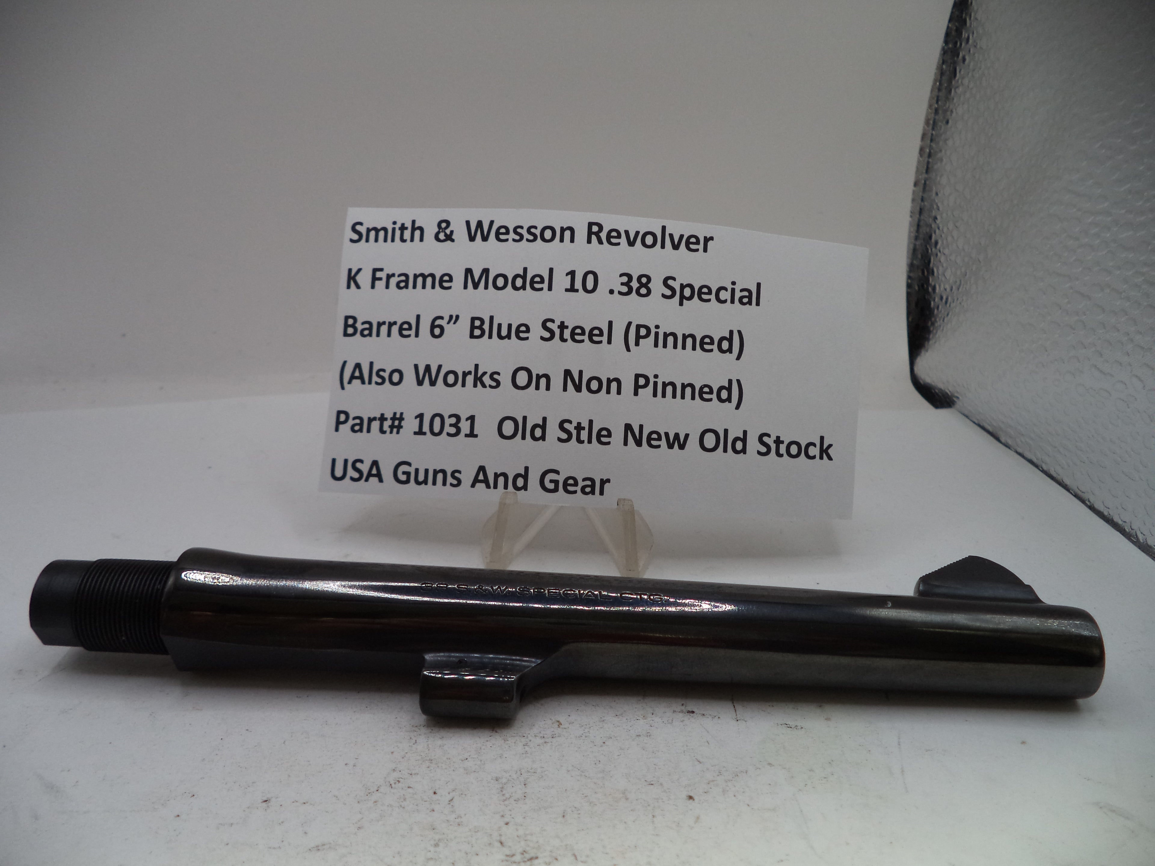 A black metal Smith & Wesson revolver barrel component displayed on a white surface with a product information card behind it.