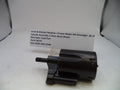 A black Smith & Wesson revolver cylinder assembly part, photographed on a white surface with a handwritten label card behind it.