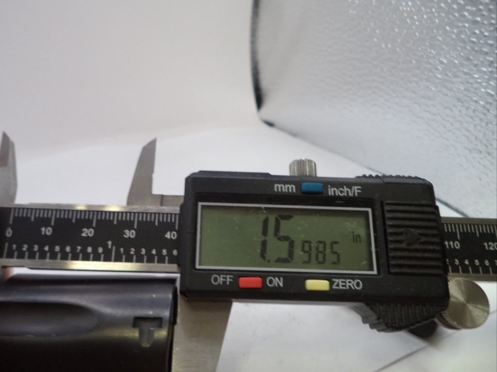 A close-up of a digital caliper being used to measure a cylindrical item, with a hand holding the left side. The caliper display shows 15.