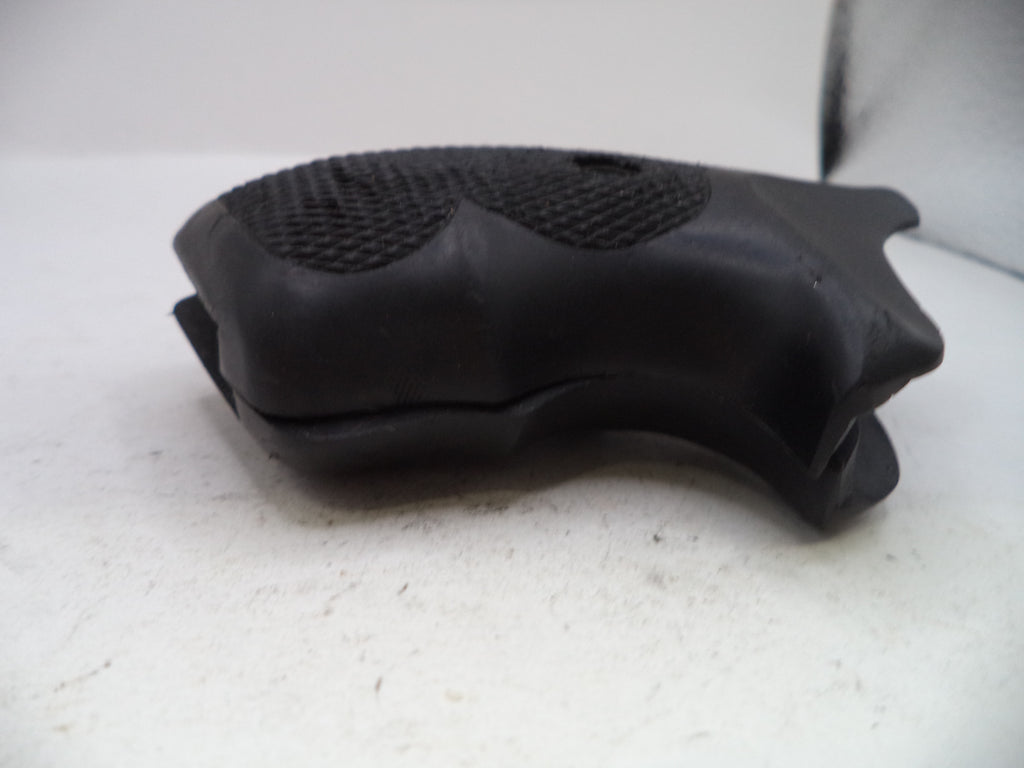 A black molded rubber or plastic grip cover with textured grip patterns, photographed on a plain off-white surface.