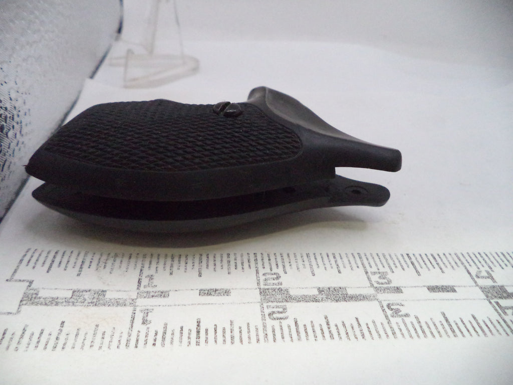 A black textured plastic clip or holder shown on a white surface with a printed ruler in the foreground for scale.