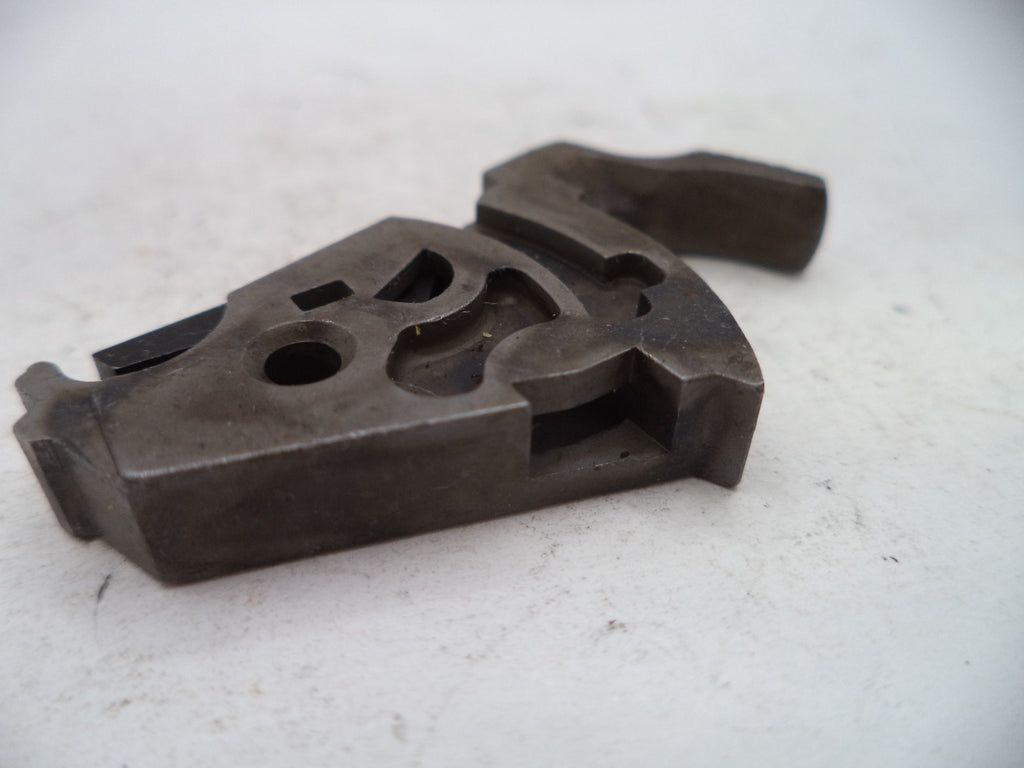 A dark metal hand tool or machinist fixture with a textured, worn surface, photographed on a light off-white background.