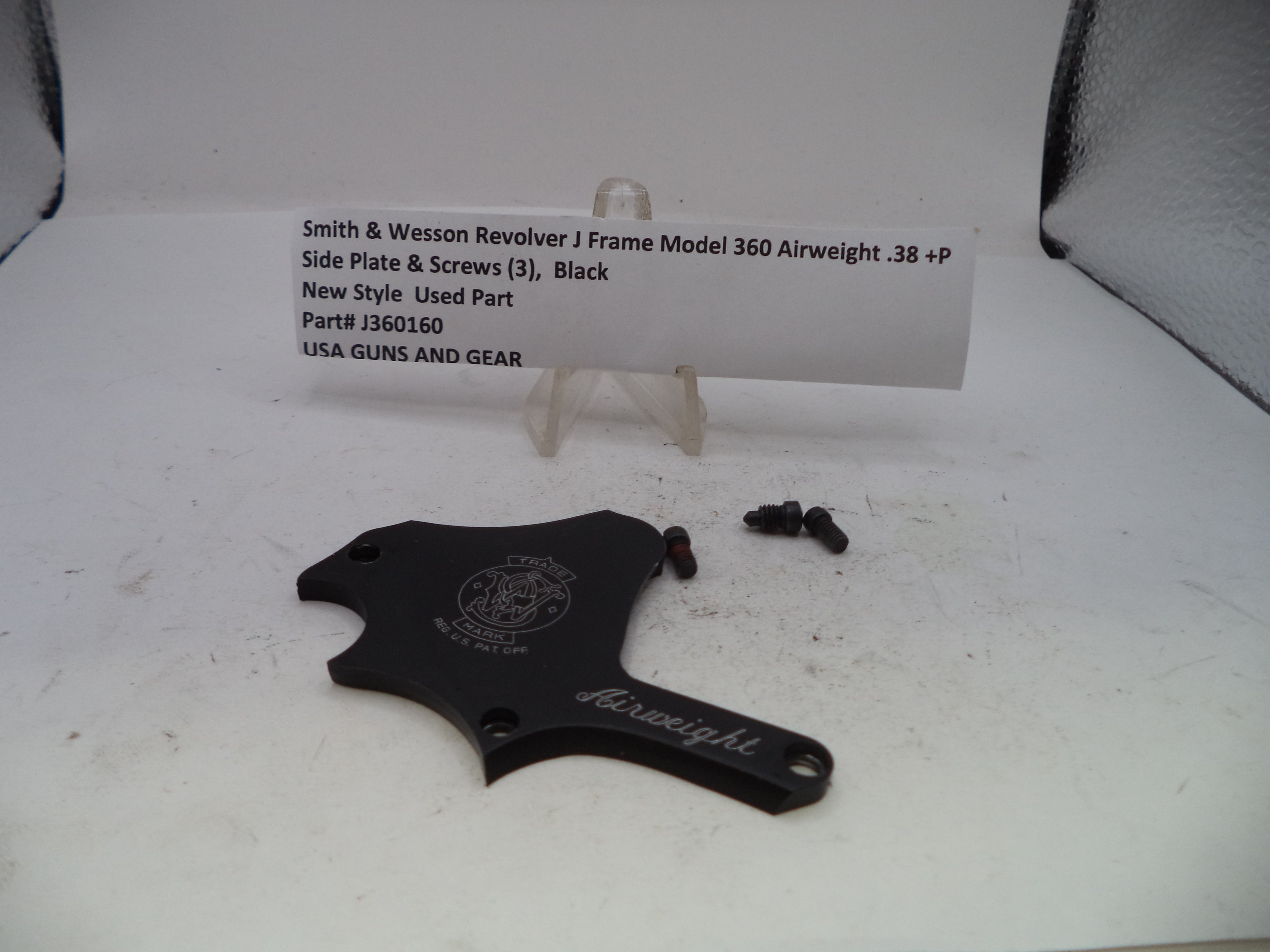 A black Smith & Wesson Revolver J Frame airweight side plate and screws, shown with a white product information card on a white surface.