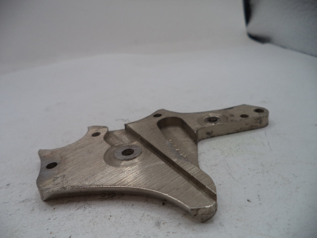 A used metal mechanical part, likely an engine or machinery bracket, with a brushed silver finish and visible wear, photographed on a white surface.