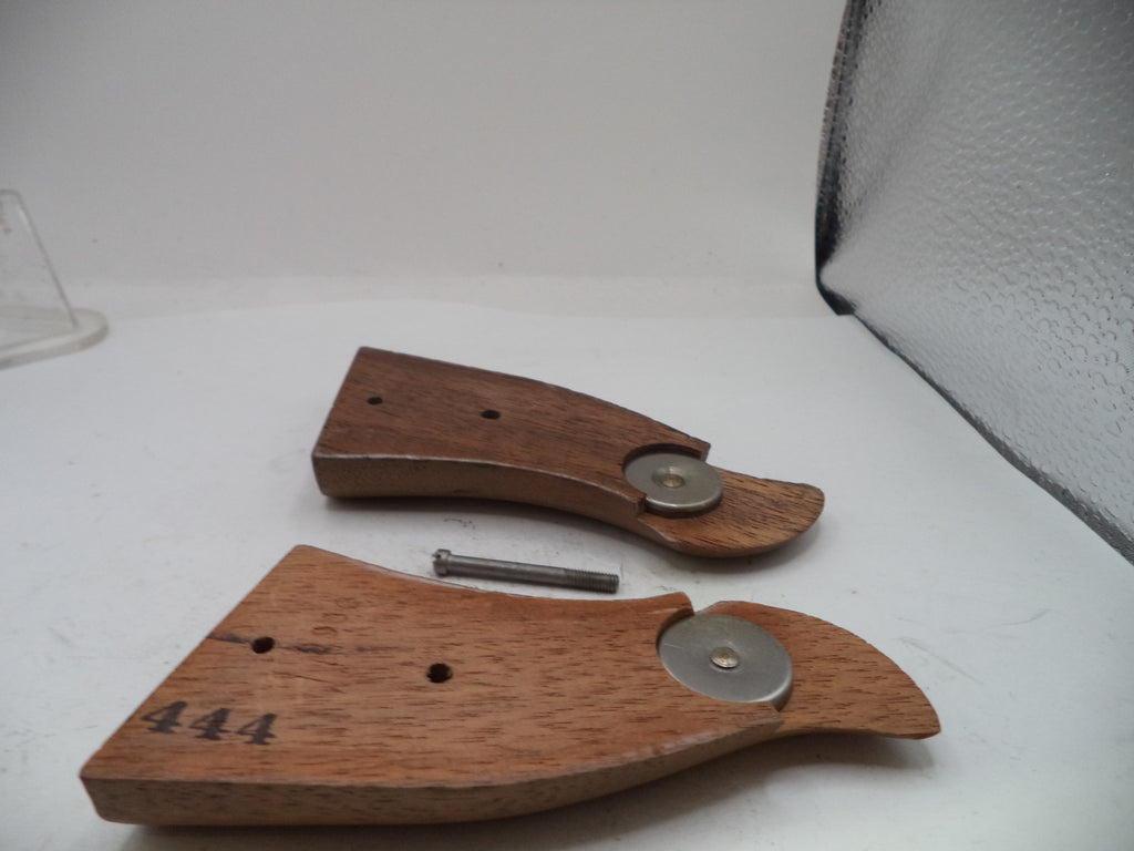 Two wooden knife block or drawer pull pieces with metal circular hardware, shown on a white surface with a small metal pin between them.