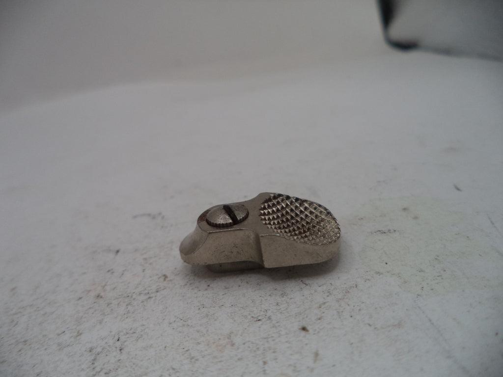 A small silver-colored metal mechanical part with a textured mesh surface and a screw, resting on a light gray surface.