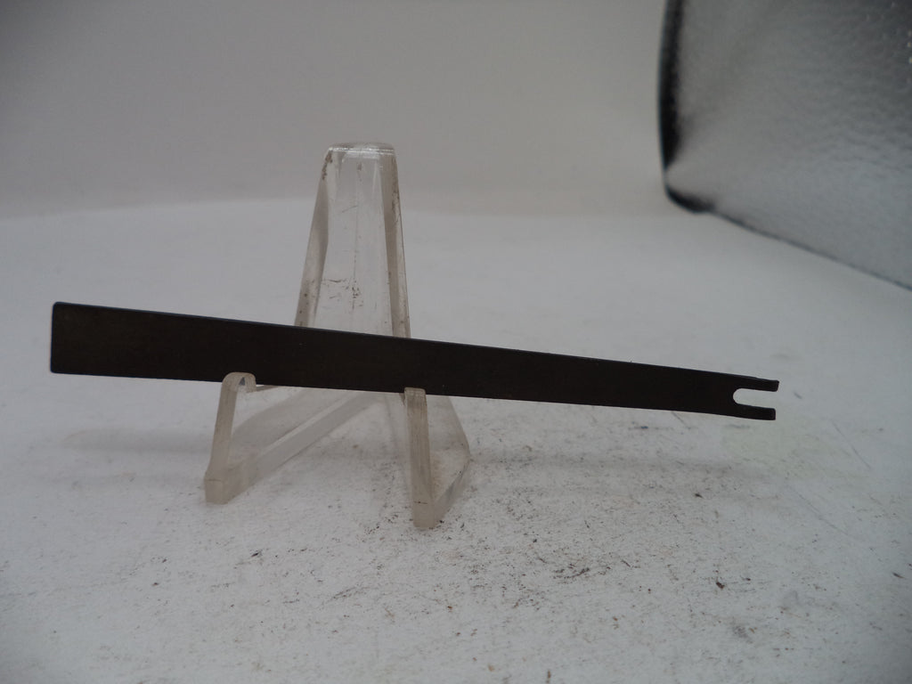 A flat metal tool with a single hook-like end, displayed horizontally on a clear plastic stand against a light gray background.