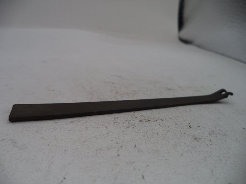 A dark metal flathead screwdriver with a bent handle, resting on a light gray textured surface.