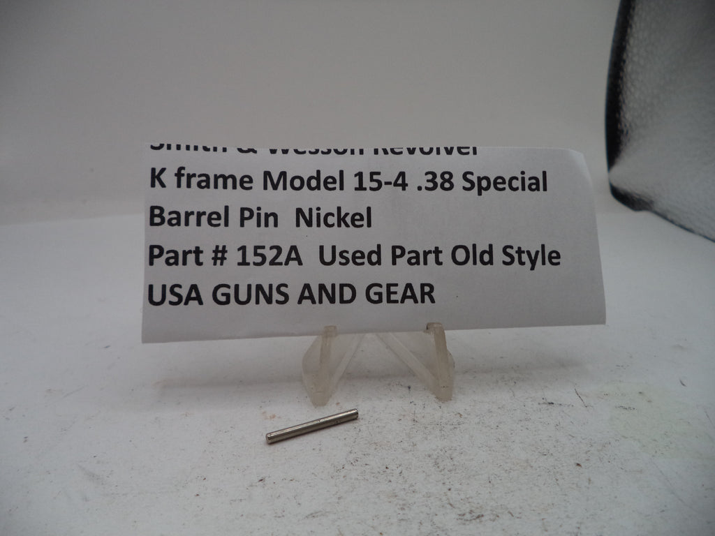 A small metal barrel pin displayed on a white surface with a printed label card behind it reading 'Smith & Wesson Revolver K frame Model 15-4 .38 Special Barrel Pin Nickel Part # 152A Used Part Old Style USA GUNS AND GEAR.