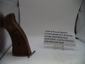 A vintage Smith & Wesson revolver K-frame stock grip part shown standing upright next to a small white label card on a white surface, with a textured silver backdrop.
