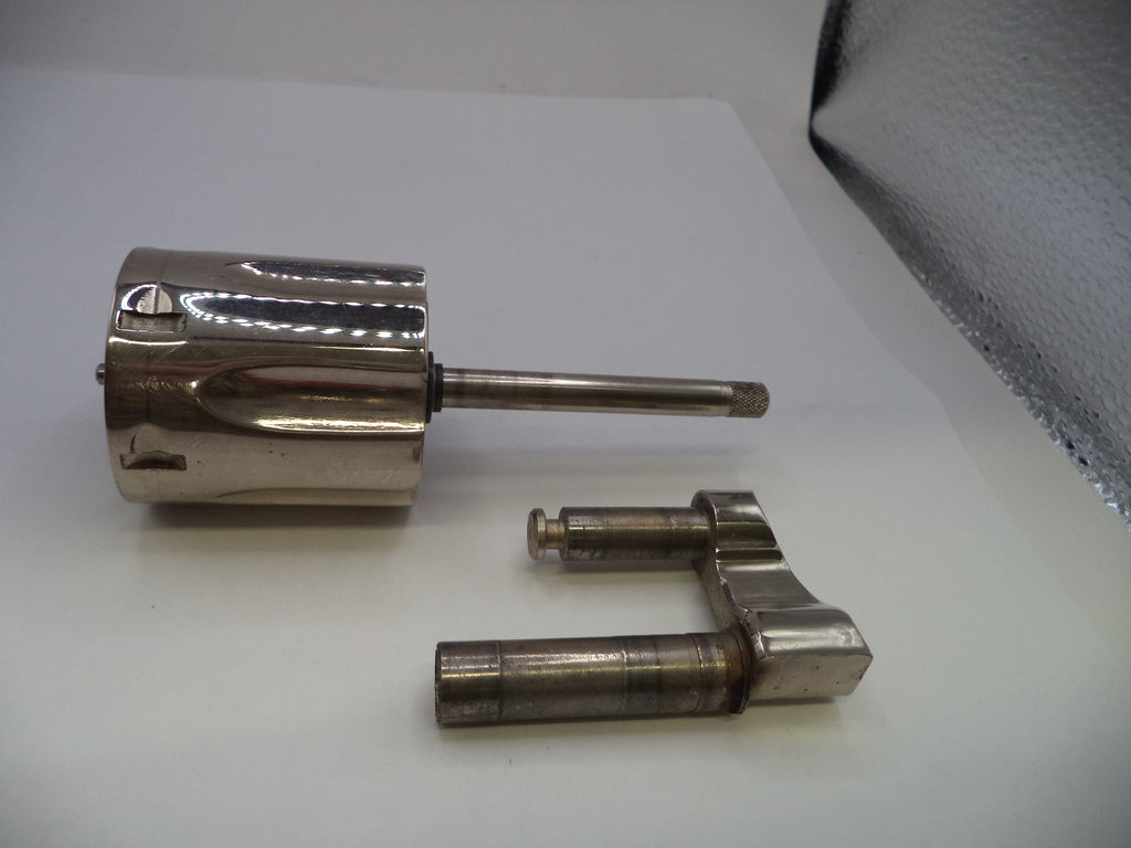 A polished metallic cylindrical component with a long horizontal rod, shown alongside a separate matching metal bracket on a plain white surface.