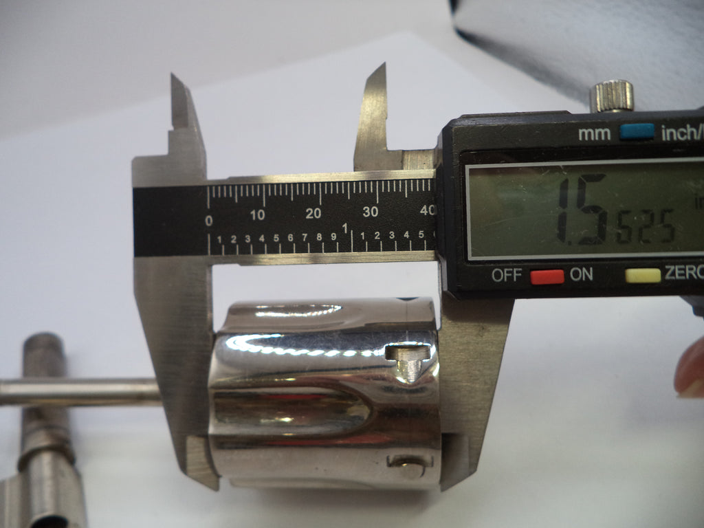 A close-up of a polished metal cylindrical component being measured with a digital caliper showing 15.525 mm.